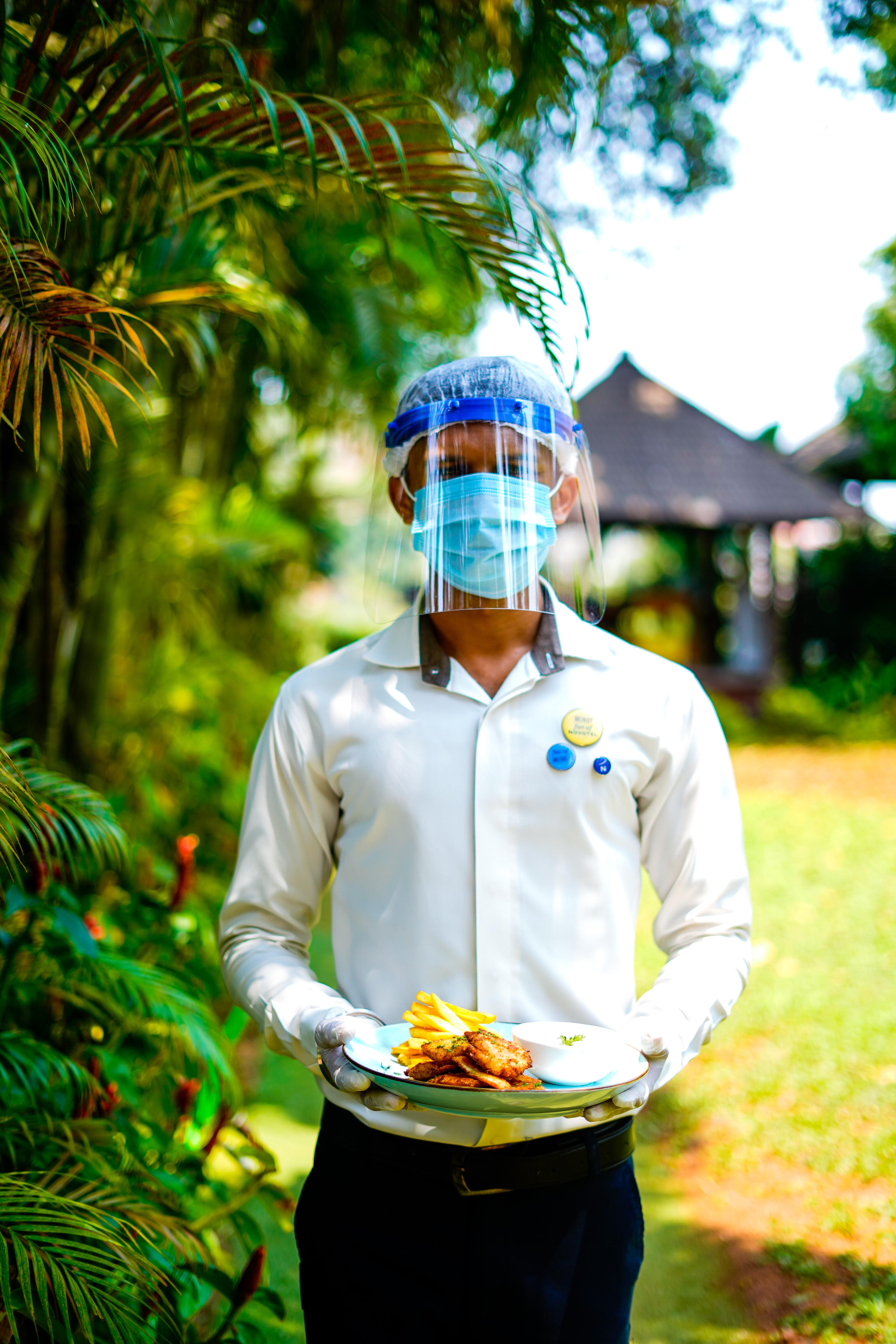 Novotel Goa Resort & Spa Candolim Extérieur photo A hotel employee wearing a face shield and a face mask